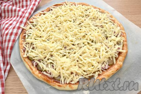 Щедро посыпаем основу для пиццы сыром, натёртым на крупной тёрке.