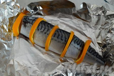 В форму для запекания выложить фольгу (если фольга тонкая, недостаточно качественная, тогда лучше выложить её в два слоя). На фольгу положить кусочки скумбрии, чередуя с полукружочками апельсина (как на фото).