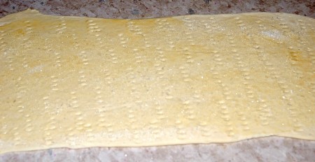 Посыпать сахаром всю поверхность пласта теста.