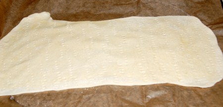 По всей поверхности пласта теста сделать проколы вилкой, чтобы при выпечке корж не вздувался.