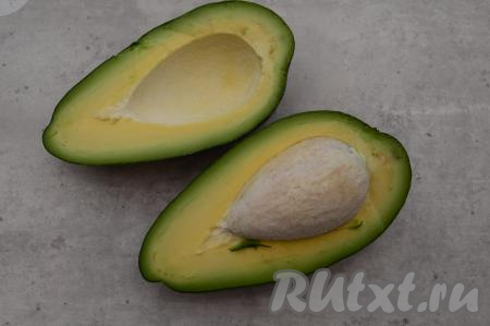 Авокадо разрезать пополам, удалить косточку и срезать кожуру ножом.