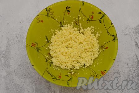 Остывшие яйца очистить от скорлупы. Отделить белок от желтка. Белки отложить, а желтки переложить в отдельную тарелку и размять вилкой в крошку.