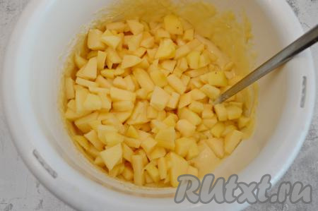 Яблоки очистить от кожуры, удалить семена. Нарезать яблоки на небольшие кубики (размером примерно 1х1 сантиметр) и выложить в бисквитное тесто.