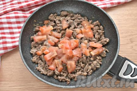 Моем помидор. Кожуру я не убирала, только срезала место, в котором находилась плодоножка. Нарезаем помидор на средние кубики и добавляем к фаршу с луком, солим, перчим, можете добавить свои любимые специи и приправы, перемешиваем. Под крышкой тушим фарш с помидорами 7-8 минут (до готовности мяса), иногда перемешивая.