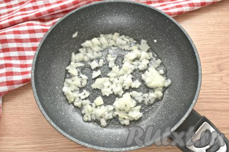 Пока варятся макароны, очищаем небольшую луковицу, мелко нарезаем и выкладываем на прогретую с растительным маслом сковороду. На среднем огне обжариваем лук, иногда перемешивая, 3 минуты (до мягкости лука).