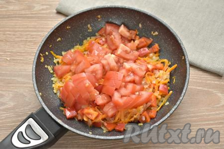 Затем к обжаренным морковке, перцу и луку выкладываем помидоры, нарезанные на маленькие кусочки, перемешиваем и томим овощи на небольшом огне минут 5, иногда помешивая.