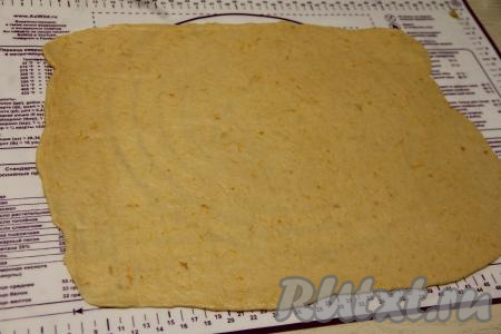 Поднявшееся тесто обмять и на припылённой мукой поверхности раскатать в прямоугольный пласт толщиной примерно 3-4 миллиметра.