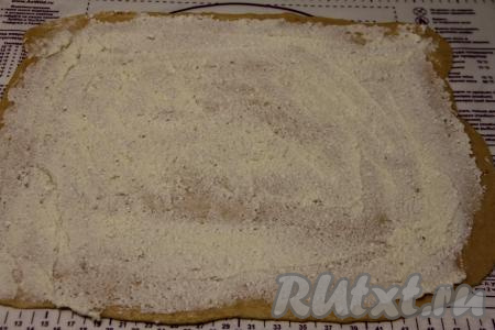 Для получения начинки нужно соединить творог, сахар и 50 грамм мягкого сливочного масла, пробить погружным блендером до получения однородного творожного крема. Получившимся кремом смазать раскатанный пласт теста.