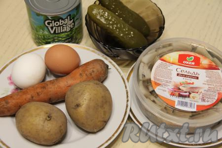 Подготовить продукты для приготовления салата "Оливье" с селёдкой. Картошку и морковь сварить в кожуре до готовности (варим после начала кипения воды минут 20-25, готовые овощи будут легко прокалываться ножом). Яйца сварить вкрутую (варим с начала закипания воды 10 минут). Остудить варёные овощи и яйца. Я использовала уже готовые кусочки филе сельди в масле, но можно взять слабосолёную селёдку и разделать её на филе самостоятельно, тщательно убирая все косточки.
