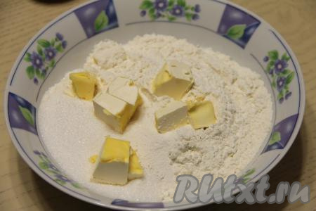 К муке, сахару, разрыхлителю и соли добавить кусочки холодного масла, перетереть тщательно массу руками в крошку.