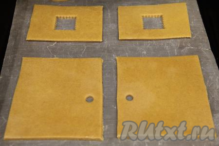 Вырезать из теста детали домика по трафарету, не забывая сформировать и основу, на которой будет стоять домик.&nbsp;Я вырезала детали домика в двойном экземпляре, так как из этого количества теста у меня получилось 2 домика высотой 16 сантиметров. Детали домика, вырезанные из пряничного теста, переложить на противень, застеленный пергаментом (или ковриком для выпечки).