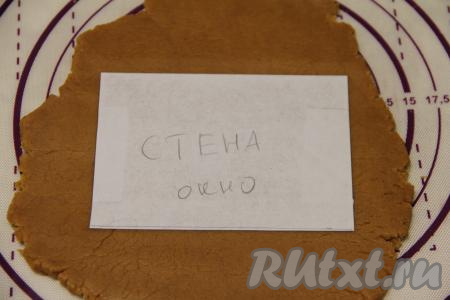 Сделать трафареты пряничного дома из бумаги. Готовое тесто разделить на несколько частей. Раскатать тесто в пласт толщиной примерно 0,5 см. Выложить трафареты дома (у меня трафареты, вырезанные из бумаги).