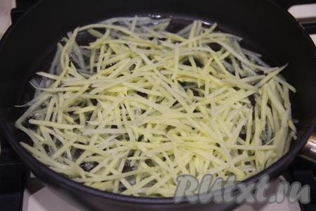 В сковороду с достаточно большим количеством хорошо разогретого растительного масла выложить небольшую часть картошки (если вы выложите на сковороду сразу весь натёртый картофель, у вас не получится хрустящий картофель фри).