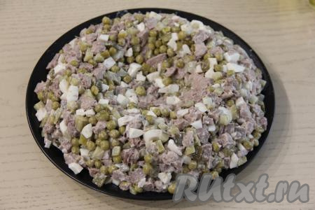 Салат выложить на круглую плоскую тарелку. В середине салата сделать небольшое углубление (наподобие формы гнезда).