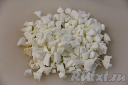 Разделить яйца на белки и желтки. Белки нарезать на кубики. Желтки нам понадобятся для оформления салата, поэтому пока отложите их в сторону.