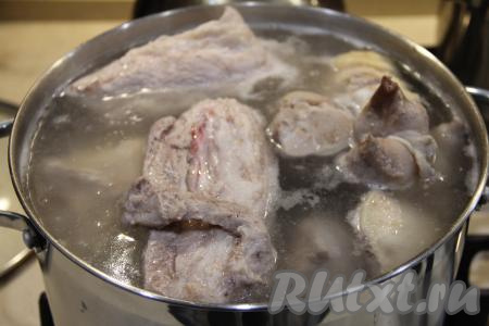 Мякоть свинины и ножки тщательно вымыть, затем переложить в глубокую кастрюлю и залить мясо холодной водой. Вода должна быть выше мяса примерно на 1 сантиметр. Поставить кастрюлю со свининой на огонь, а после закипания уменьшить огонь, убрать пену.