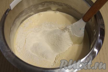 К яйцам, взбитым с сахаром, влить молоко и растительное масло, перемешать лопаткой в течение 1 минуты. Затем всыпать разрыхлитель, частями начать добавлять муку, перемешивая бисквитное тесто лопаткой движениями снизу вверх.