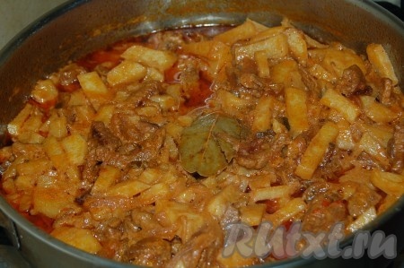 Затем выложить поверх обжаренного картофеля тушеное мясо с огурцами и луком (картофель и мясо с овощами при желании можно чередовать слоями), добавить лавровый лист, соль, перец. По желанию можно добавить в азу горячей воды. Закрыть крышкой и тушить 30 минут.