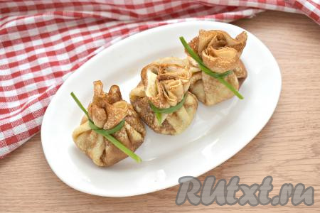 Края блина с грибным жульеном собираем к центру в виде мешочка и перевязываем одним пером зелёного лука.