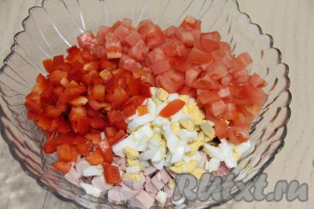 Половину болгарского перца очистить от семян. Помидор и перец промыть водой, нарезать на небольшие кубики и выложить в салатник.