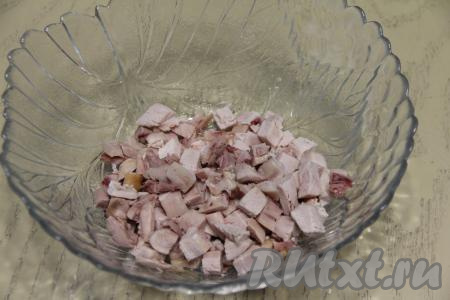 Нарезать копчёную курицу на небольшие кубики и выложить в салатник.