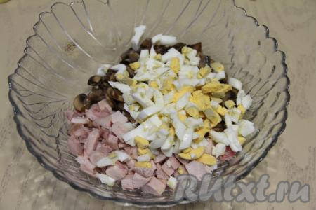 Нарезать яйца на небольшие кубики, тоже добавить в салатник.