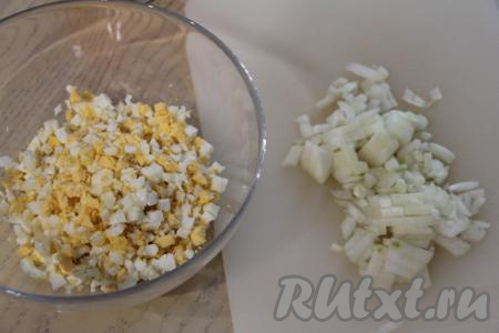 Яйца сварить вкрутую (варить после закипания воды 10 минут), после этого остудить и очистить. Нарезать яйца на небольшие кубики, переложить в миску.&nbsp;Почистить половину луковицы, мелко нарезать, залить кипящей водой и сразу слить кипяток, переложив лук на сито, после этого промыть очень холодной водой, дать стечь лишней воде. Благодаря такому способу обработки, лук потеряет свою горечь, но останется достаточно хрустящим. Если хотите, чтобы лук был более нежным, тогда нарезанный лук не ошпаривайте кипятком, а обжарьте на растительном масле, помешивая, до мягкости, а затем остудите.