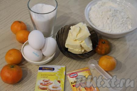 Подготовить продукты для приготовления рождественского мандаринового кекса. Заранее достать из холодильника сливочное масло, постепенно оно согреется при комнатной температуре и размягчится. Мандарины тщательно вымыть, снять с мандаринок цедру (снимая оранжевый слой с мандариновой кожуры, старайтесь не затрагивать находящийся под ней белый слой). Выдавить сок из мандаринов и процедить. Нам понадобится 1 чайная ложка цедры и 100 миллилитров мандаринового сока.