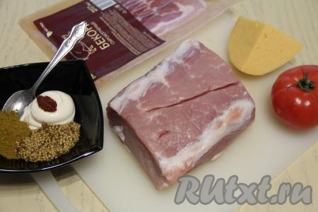 Подготовить продукты для приготовления свинины в духовке с беконом и сыром. Кусок мякоти свинины промыть водой и обсушить. Для получения маринада майонез, соль, горчицу и аджику соединить в глубокой пиале и перемешать.