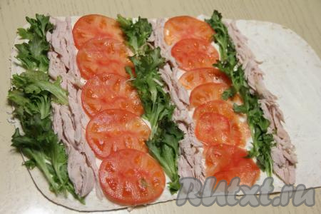 Помидор нарезать на тонкие кружочки. Мясо копчёной курочки нарезать на тонкие пластинки. Выложить начинку, чередуя полоски: зелёный салат, курица, помидор. Край лаваша оставить чистым, как на фото.