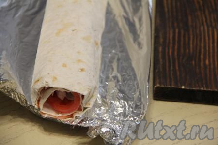 Завернуть рулет в фольгу и убрать на час в холодильник, чтобы он как следует пропитался.