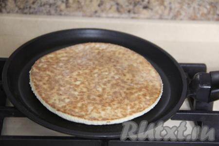 Выпекать корж с двух сторон на среднем огне до золотистого цвета. Затем переложить на тарелку. Постепенно приготовить все коржи.