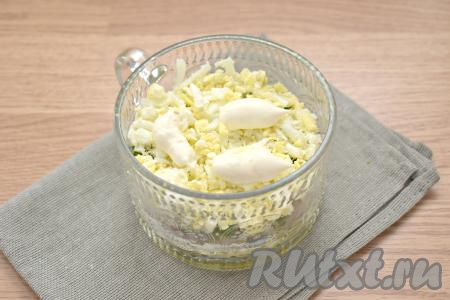 Следующим слоем будут яйца, натёртые на крупной тёрке, немного солим и смазываем майонезом.