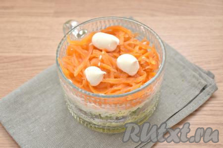 На яичный слой выкладываем натёртую на крупной тёрке морковку, смазываем немного майонезом.