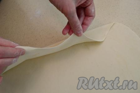 Раскатываем тесто в круг максимально тонко на хорошо припылённой мукой поверхности. Тесто нужно раскатывать практически до прозрачности, но и рваться оно не должно. Тесто приятное в работе, поэтому раскатывается легко и достаточно быстро (я в процессе раскатывания переворачивала тесто со стороны на сторону, слегка припыляя его мукой).