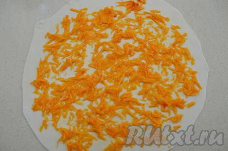 Затем распределяем по тесту 1/4 части начинки, отступив пару сантиметров от края. Если натёртая тыква снова даст сок, тогда перед выкладыванием на тесто слегка отожмите тыкву рукой, чтобы лишний сок не размачивал тесто.