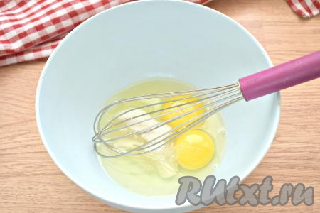 В миску разбиваем куриные яйца, всыпаем соль и сахар, перемешиваем ручным венчиком до однородности.