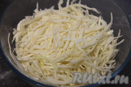 Пока маринад готовится, капусту тонко нарезать и выложить в глубокую миску, помять руками.