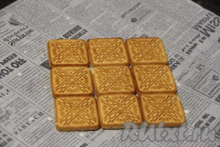 Печенье обмакнуть в молоко и выложить либо в форму, либо на пергамент. У меня получился квадратный тортик, можно сделать прямоугольный. Я первым слоем выложила 9 печенюшек.