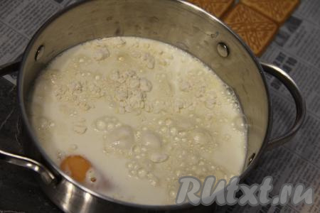 Сюда же влить молоко, перемешать массу венчиком и поставить на средний огонь. Постоянно помешивая, довести крем до кипения. Как только крем закипит, он сразу загустеет.