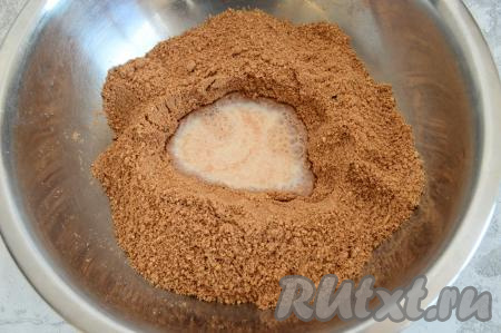 В получившуюся массу частями начать вливать тёплое молоко, тщательно вмешивая его в тесто для наших пирожных вначале ложкой.