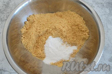 Переложить крошку из печенья в глубокую миску, всыпать к ней сахарную пудру.