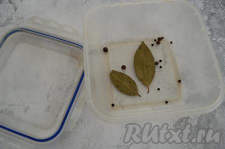 После того как рассол остынет до комнатной температуры, взять контейнер (или другую удобную для засолки посуду). В контейнер всыпать горошины чёрного и душистого перцев, выложить лавровый лист.