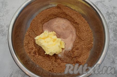 К сухой смеси добавить сливочное масло комнатной температуры, нарезанное на кусочки, влить горячее молоко (я предварительно подогрела молоко в течение 1 минуты в микроволновке на максимальной мощности). Я стараюсь вливать молоко поверх масла, чтобы масло лучше растапливалось.