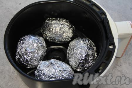 Выложить картошку, завёрнутую в фольгу, в чашу аэрогриля на решётку, крышку закрыть. Готовить при температуре 190 градусов минут 40 (продолжительность запекания зависит от размера и сорта картофеля). Готовность проверить зубочисткой: если она входит без усилий в картофельную мякоть, значит наша картошечка готова.