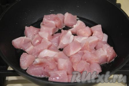 В сковороду с высокими бортиками влить растительное масло, разогреть его. Переложить кусочки индейки в сковороду.