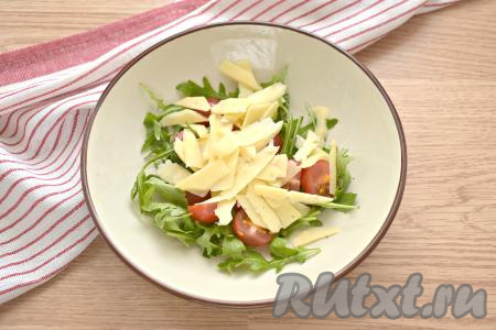 Пармезан нарезаем на тонкие пластинки и перекладываем в салат из рукколы и черри.