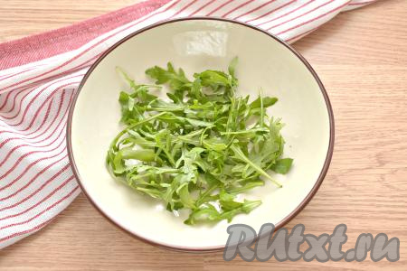 Рукколу ополаскиваем водой, обсушиваем, а затем перкладываем в салатник.
