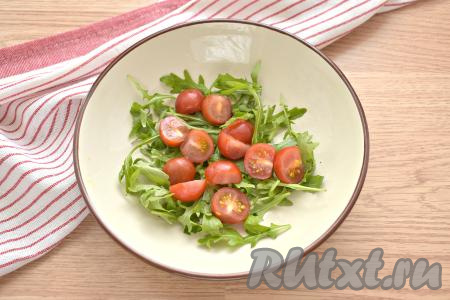 Промываем помидоры черри, разрезаем их на 2 половинки и добавляем к рукколе.