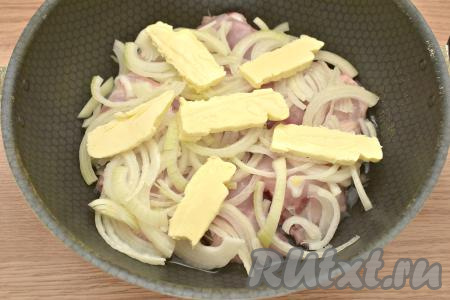 Поверх лука выкладываем кусочки сливочного масла, как на фото. Затем вливаем в сковороду 100 миллилитров тёплой кипячёной воды.